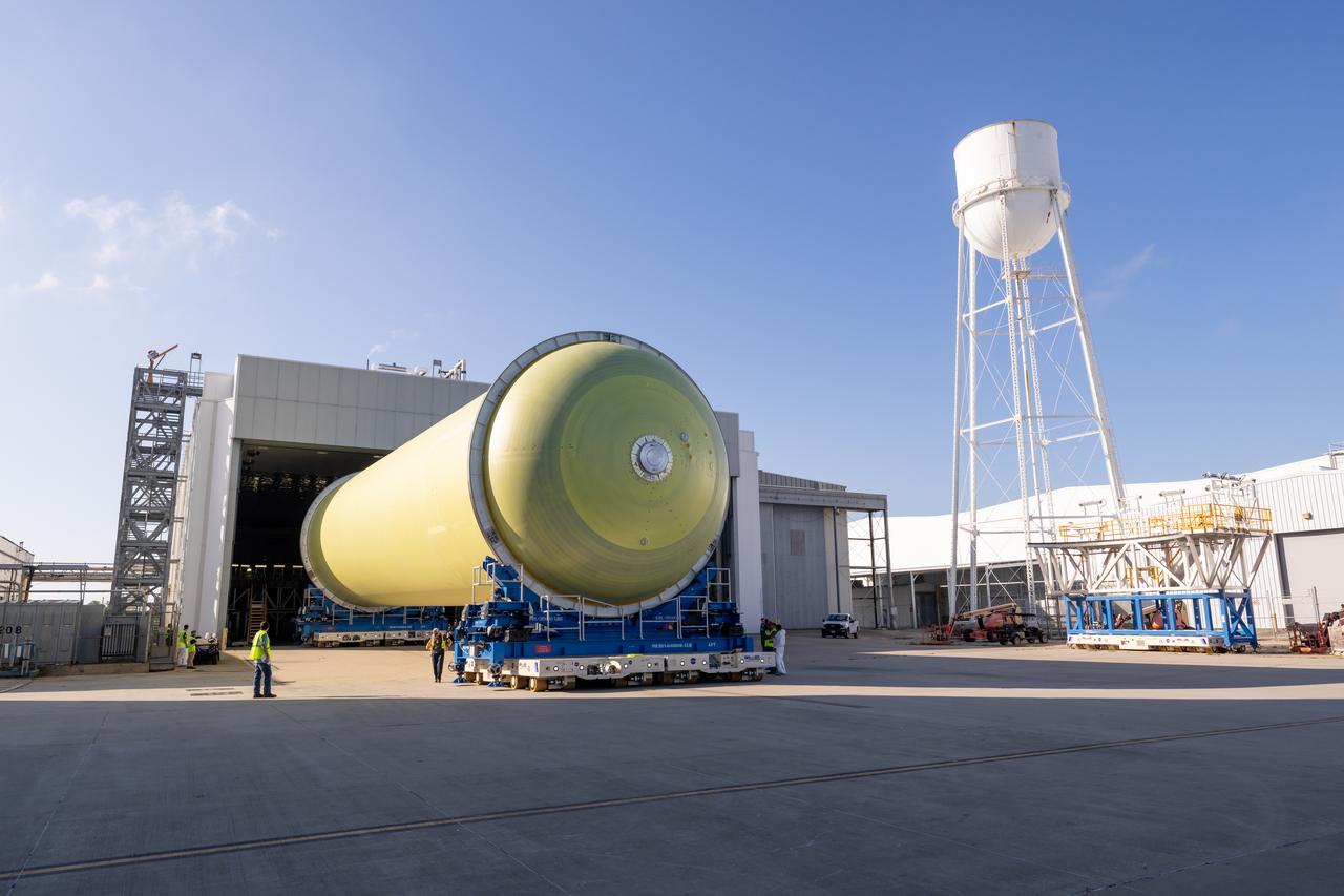 Teams move a liquid hydrogen tank for NASA’s SLS (Space Launch System) rocket out of a priming cell and into an adjacent cell on May 20 at the agency’s Michoud Assembly Facility in New Orleans. Inside the cell, the tank, which will be used on the core stage of NASA’s Artemis III mission, will receive its thermal protection system.  The thermal protection system, or spray-on foam insulation, provides protection to the core stage during launch. It is flexible enough to move with the rocket yet can withstand the aerodynamic pressures as the SLS accelerates from 0 to 17,500 mph and soars to more than 100 miles above the Earth. This third-generation insulation is more environmentally friendly and keeps the cryogenic propellant, which powers the rocket’s four RS-25 engines, extremely cold (the liquid hydrogen must remain at minus 423 degrees Fahrenheit/253 degrees Celsius) to remain in its liquid state. When applied the thermal protection system is a light-yellow color, which “tans” once exposed to the Sun’s ultraviolet rays, giving the SLS core stage its signature orange color.